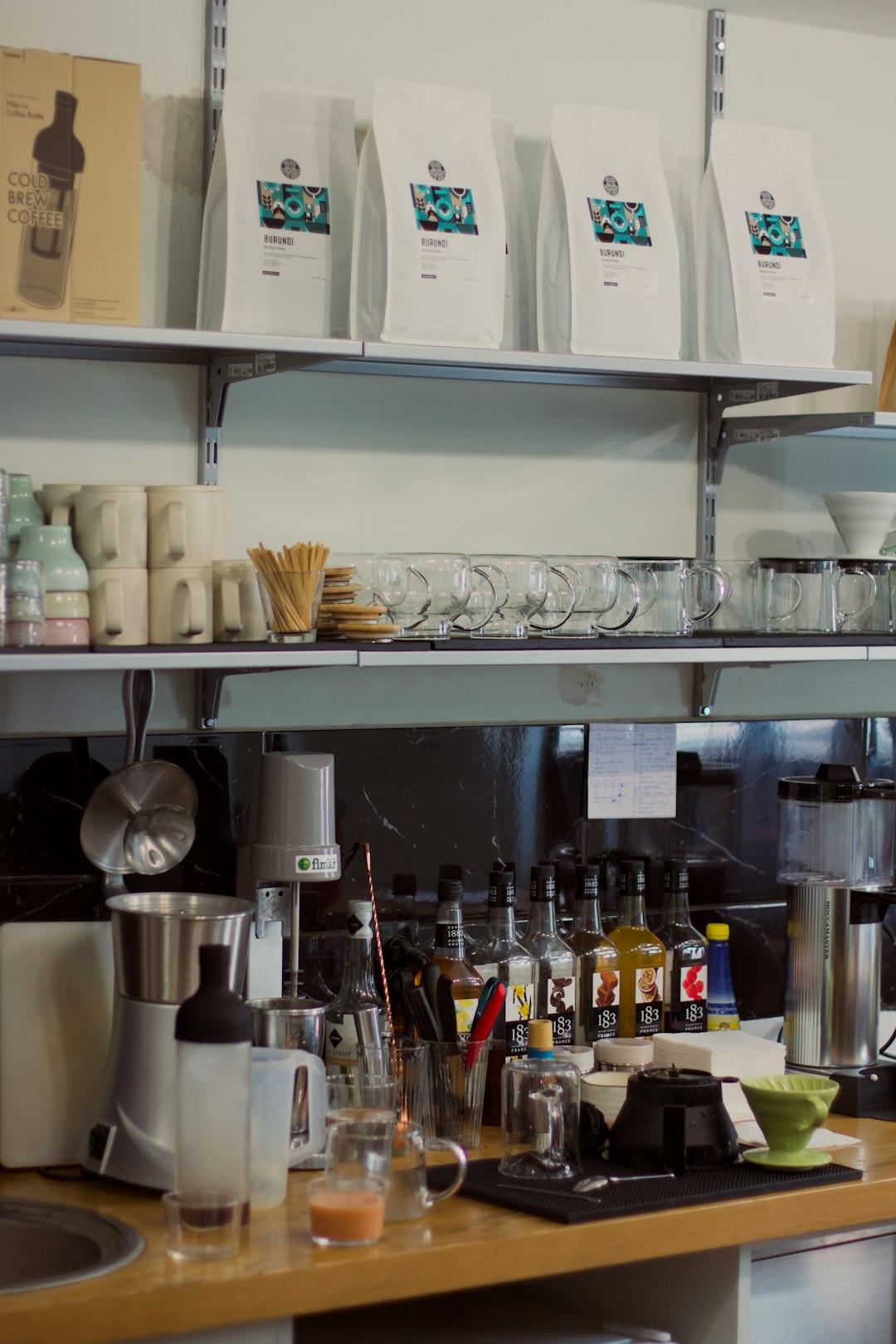 A coffee shop with a counter full of cups and saucers