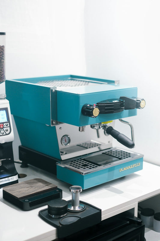 A blue coffee machine sitting on top of a counter
