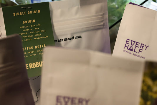 Paquets de café de spécialité alignés, étiquettes détaillant l'origine et le niveau de torréfaction