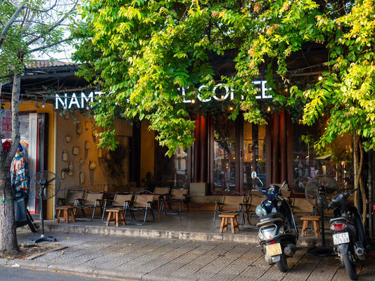 Outdoor cafe with trees and parked motorcycles