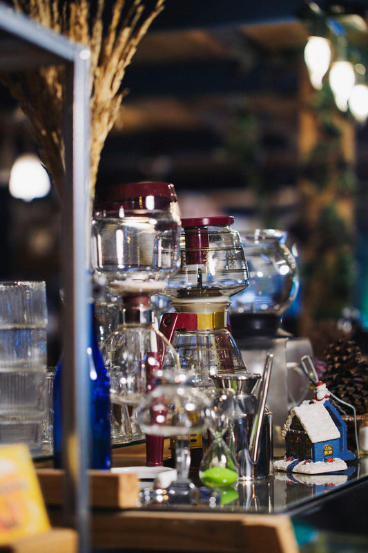 Glass jars and coffee brewing equipment on a shelf.