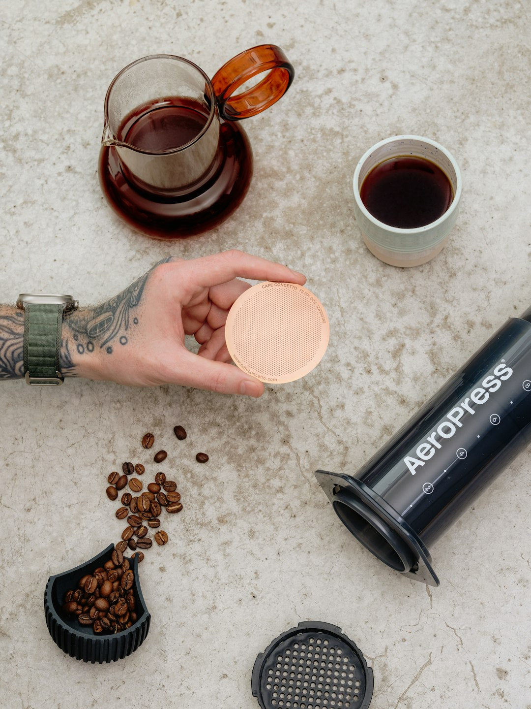 Aeropress coffee maker with beans and brewed coffee