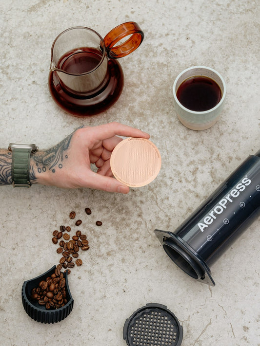 Aeropress coffee maker with beans and brewed coffee